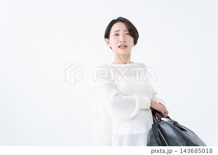 重い鞄を持つ女性 重い鞄を持つ女性 143685018