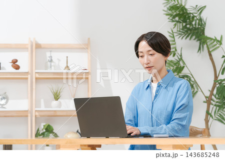 リビングでパソコンを使う若い女性 143685248