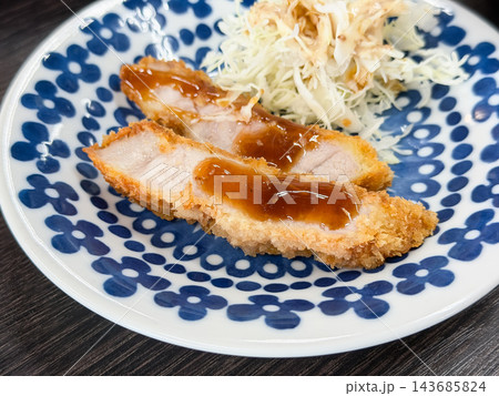 ソースをつけたとんかつ。豚ロース肉を揚げた和食。 ソースをつけたとんかつ。豚ロース肉を揚げた和食。 143685824