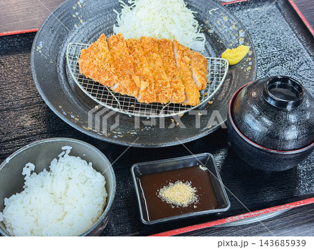 とんかつ定食。豚ロース肉を揚げた和食。キャベツの千切りを添えて。 143685939