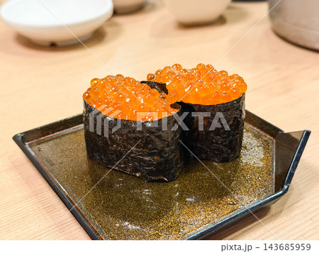いくらの軍艦巻き寿司。海苔で巻いた酢飯の上に乗せたいくら。 いくらの軍艦巻き寿司。海苔で巻いた酢飯の上に乗せたいくら。 143685959