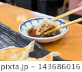 タレにつけて食べる餃子。断面のクローズアップ。 143686016