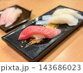 中とろの握り寿司。新鮮な中とろマグロの刺身と酢飯を握った和食。いかの握り寿司を背景に。 143686023