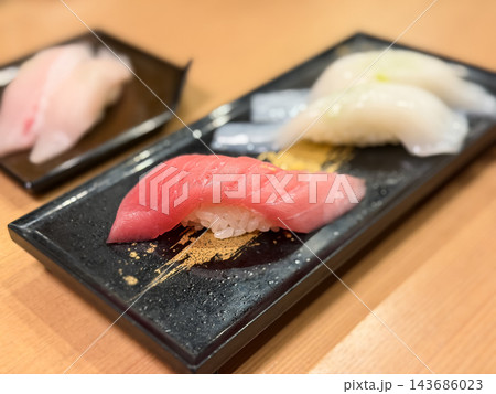 中とろの握り寿司。新鮮な中とろマグロの刺身と酢飯を握った和食。いかの握り寿司を背景に。 143686023