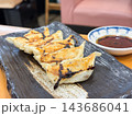 焦げの付いた焼き餃子。タレを添えて。 143686041
