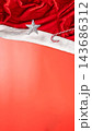 Christmas background with Santa hat, silver star ornament, and candy cane on vibrant coral backdrop with copy space. Concept of Merry Christmas 143686312
