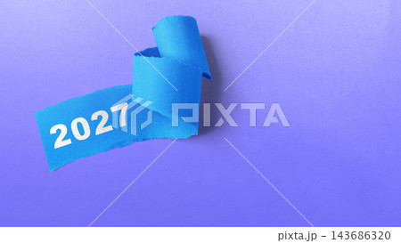 Blue torn paper with the year 2027 written on it, isolated on a purple background. Concept of Happy New Year 143686320