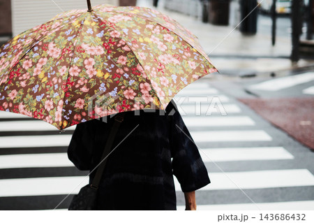 雨の日に横断歩道を渡る高齢者の後ろ姿 雨の日に横断歩道を渡る高齢者の後ろ姿 143686432