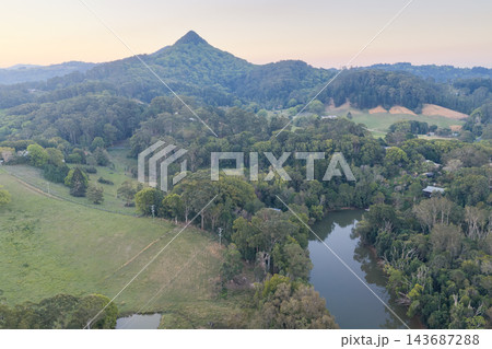 Aerial view along the Brunswick River and forested hinterland toward Mount Chincogan at sunset near Mullumbimby, New South Wales, Australia. 143687288