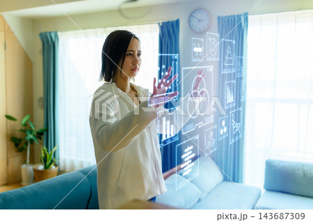 ホログラムのグラフを操作してデータ分析する若い女性 143687309