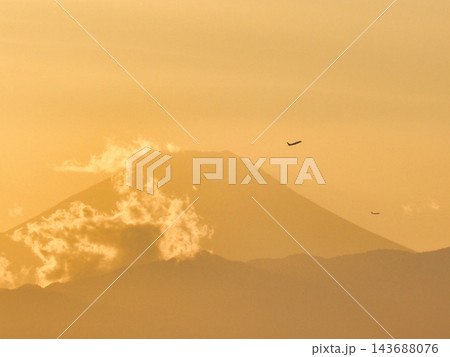 夕焼けに染まる空を飛ぶ飛行機と富士山 夕焼けに染まる空を飛ぶ飛行機と富士山 143688076