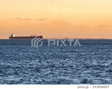 夕暮れの海を航行する貨物船 夕暮れの海を航行する貨物船 143688087