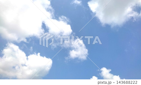 Vibrant Blue Sky with Scattered Fluffy White Clouds on a Sunny Day Vibrant Blue Sky with Scattered Fluffy White Clouds on a Sunny Day 143688222