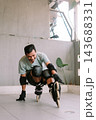 Person practicing inline skating and balancing outdoors in protective gear 143688331