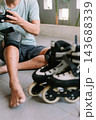 Person preparing protective gear before inline skating outdoors 143688339