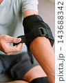 Person securing protective elbow pad for inline skating activity 143688342