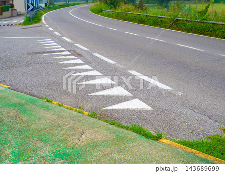 The image shows asphalt road markings shaped like white triangles 143689699
