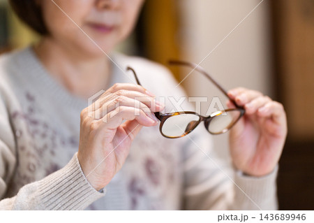 老眼鏡を持つミドル・シニア女性 老眼鏡を持つミドル・シニア女性 143689946