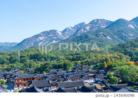 Traditional Korean Hanok Houses and Tiled Roofs against Bukhansan Mountain in Eunpyeong Hanok Village, Seoul 143690096