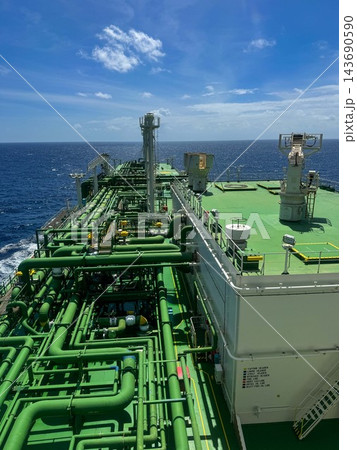 High angle view of a cargo piping system on the deck of an industrial oil tanker ship sailing in open sea. High angle view of a cargo piping system on the deck of an industrial oil tanker ship sailing in open sea. 143690590