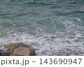 岩に打ち寄せる波 143690947