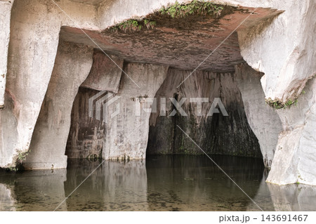 Interior of the limestone cave with reflected water in the Grotta dei Cordari in Syracuse, Italy Interior of the limestone cave with reflected water in the Grotta dei Cordari in Syracuse, Italy 143691467