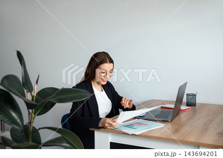 Beautiful Business Woman Working With Documents at Office Desk With Laptop. Corporate Workplace and Paperwork Concept Beautiful Business Woman Working With Documents at Office Desk With Laptop. Corporate Workplace and Paperwork Concept 143694201