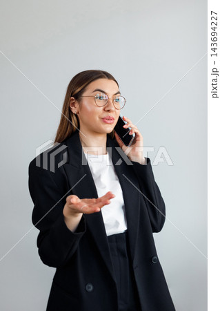 Business Woman Talking on Smartphone and Gesturing at Office. Corporate Workplace and Communication Concept. Female Professional 143694227