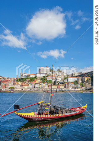 Rabelo boat on the Douro River facing Porto Ribeira, Portugal, with old town architecture and Vila Nova de Gaia riverside Rabelo boat on the Douro River facing Porto Ribeira, Portugal, with old town architecture and Vila Nova de Gaia riverside 143695976