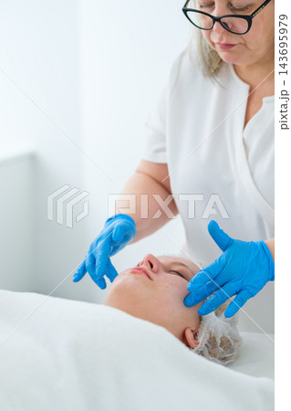 Professional beauty salon service featuring facial massage, an esthetician, face massage, skincare treatment, a woman, and a beautician during a specialist wellness session Professional beauty salon service featuring facial massage, an esthetician, face massage, skincare treatment, a woman, and a beautician during a specialist wellness session 143695979