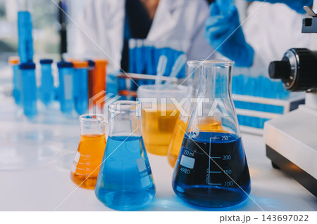 Medical or scientific researcher or man doctor looking at a test tube of clear solution in a laboratory Medical or scientific researcher or man doctor looking at a test tube of clear solution in a laboratory 143697022