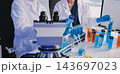 Medical or scientific researcher or man doctor looking at a test tube of clear solution in a laboratory 143697023