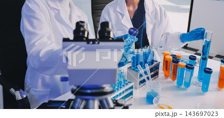 Medical or scientific researcher or man doctor looking at a test tube of clear solution in a laboratory Medical or scientific researcher or man doctor looking at a test tube of clear solution in a laboratory 143697023