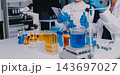 Medical or scientific researcher or man doctor looking at a test tube of clear solution in a laboratory 143697027