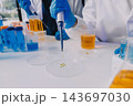 Medical or scientific researcher or man doctor looking at a test tube of clear solution in a laboratory 143697030