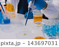 Medical or scientific researcher or man doctor looking at a test tube of clear solution in a laboratory 143697031