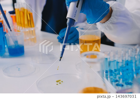 Medical or scientific researcher or man doctor looking at a test tube of clear solution in a laboratory 143697031