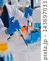 Medical or scientific researcher or man doctor looking at a test tube of clear solution in a laboratory 143697033