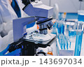 Medical or scientific researcher or man doctor looking at a test tube of clear solution in a laboratory 143697034