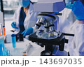 Medical or scientific researcher or man doctor looking at a test tube of clear solution in a laboratory 143697035