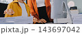 Two Asian business women looking at tablet and working together in office workspace. 143697042