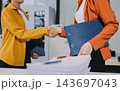 Two happy businesswomen collaborating in a modern office 143697043