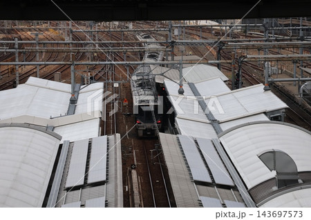 電車の車両が入ってくる駅のホームと屋根と線路のレールの風景 電車の車両が入ってくる駅のホームと屋根と線路のレールの風景 143697573