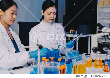 Medical or scientific researcher or man doctor looking at a test tube of clear solution in a laboratory Medical or scientific researcher or man doctor looking at a test tube of clear solution in a laboratory 143697747