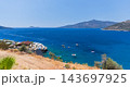Sunlit Mediterranean bay with deep blue water and small boats 143697925