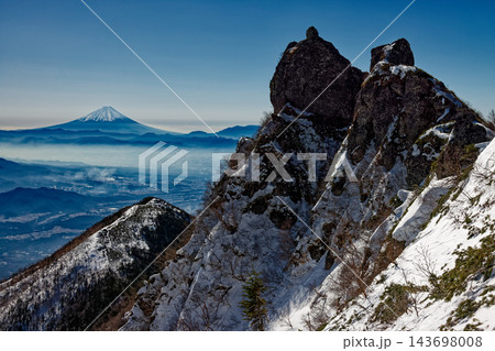 冬の八ヶ岳連峰・権現岳の岩峰と富士山 143698008