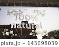 Shop window sign reading 100 percent natural with leaf decorations 143698039
