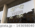 Vegan sign with decorative leaves in a glass shop window 143698040