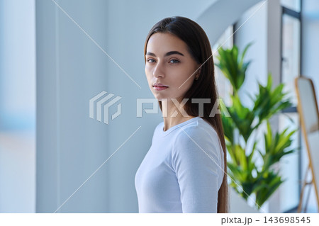 Serious young female student looking at camera in modern indoor setting 143698545