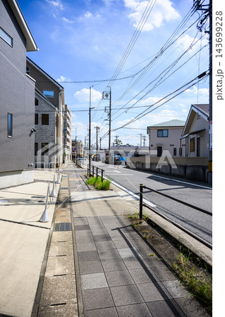 青空の下に住宅と電柱、電線が続く歩道と道路を縦構図で撮影した静かな住宅街の都市風景写真素材 青空の下に住宅と電柱、電線が続く歩道と道路を縦構図で撮影した静かな住宅街の都市風景写真素材 143699228